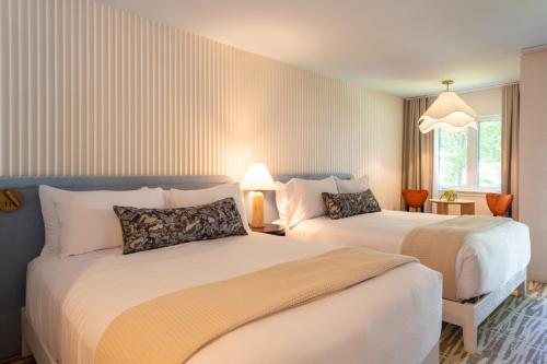 a hotel room with two beds and a window at The Meadowmere Resort in Ogunquit