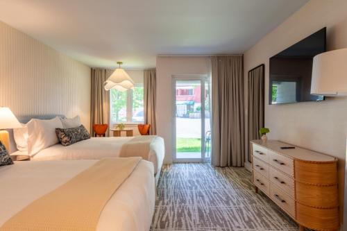 a hotel room with two beds and a window at The Meadowmere Resort in Ogunquit