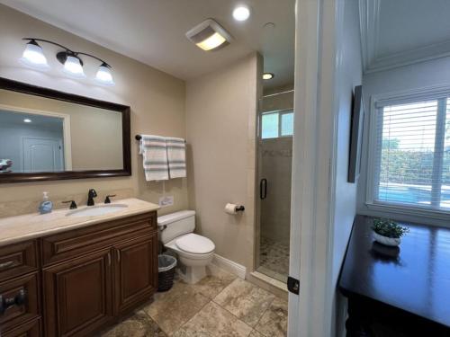 a bathroom with a toilet and a sink and a shower at Gorgeous Pool Home 1/2 Mile Walk to Disney in Anaheim