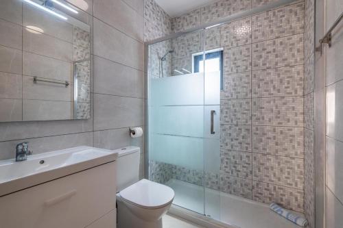 a bathroom with a shower and a toilet and a sink at Villa Miramar Gale by Villa Select in Galé
