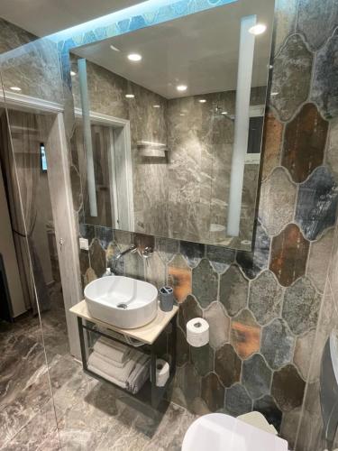 a bathroom with a sink and a toilet and a mirror at Dionisia apartments in Kos