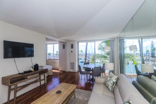 a living room with a white couch and a tv at Ilikai Marina 382 in Honolulu