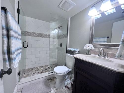 a bathroom with a toilet and a sink and a shower at Luxurious 2 Bedroom Condo Shortest Walk To Disney in Anaheim