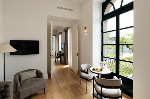 a living room with a table and chairs at Oca Grande Hotel Do Pezo in Melgaço