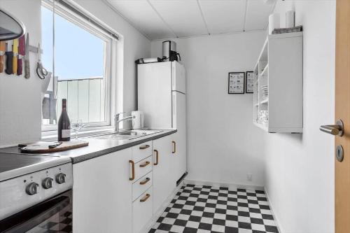 a white kitchen with a black and white checkered floor at SJ236-Haderslev-Blokhusskoven-53 in Haderslev