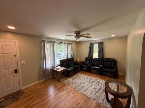 a living room with leather chairs and a ceiling fan at The Vineyard House | Spacious Home Near Wine, Beer & Lake MI in Bridgman