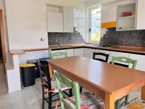 a kitchen with a wooden table and chairs at Appartamento Arena by OTIUM in Giulianova