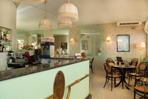 cocina y comedor con mesa y sillas en Hotel Loreley, en Isquia