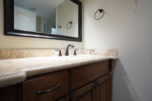 a bathroom with a sink and a mirror at Comfy Pool Home,1/4 mile Walk To Disneyland in Anaheim