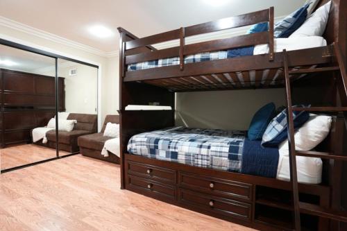 a bedroom with two bunk beds and a mirror at Comfy Pool Home,1/4 mile Walk To Disneyland in Anaheim