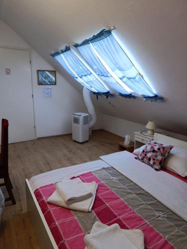 a bedroom with a large bed with a blue window at Rooms IVKA in Plitvička Jezera