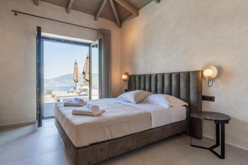 a bedroom with a large bed and a large window at Villa Ouranos by Villa Select in Fiskardo