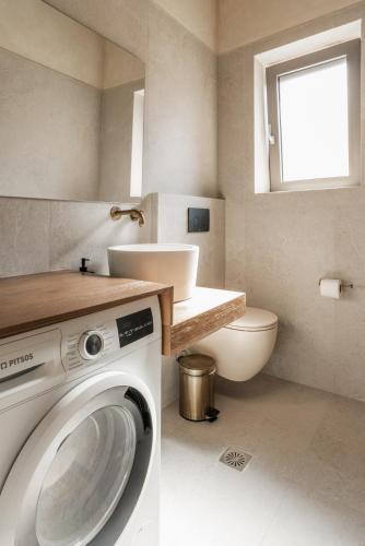 a washing machine in a bathroom with a sink at Villa Ouranos by Villa Select in Fiskardo