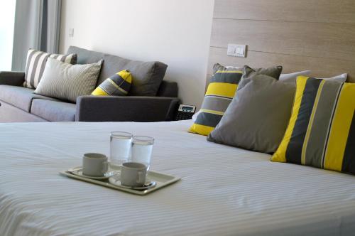 a bed with two cups and two saucers on it at Island Boutique Hotel in Larnaka
