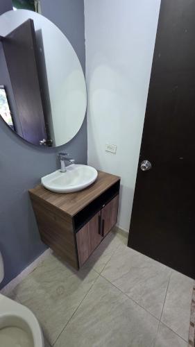 a bathroom with a sink and a mirror and a toilet at CASA HOTEL COCORNa in Cocorná