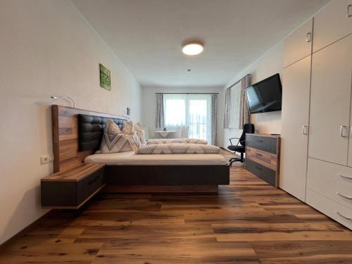 a bedroom with a large bed and a flat screen tv at Panoramablick Zirbitzkogel in Perchau am Sattel