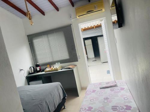 a bedroom with a bed and a sink and a mirror at Pousada Coral in Osório