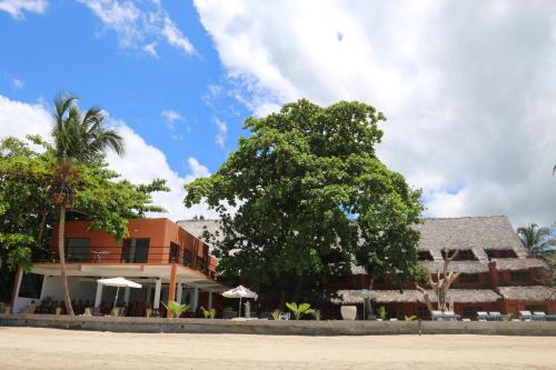 a building with a tree in front of it at Nosy Lodge in Nosy Be
