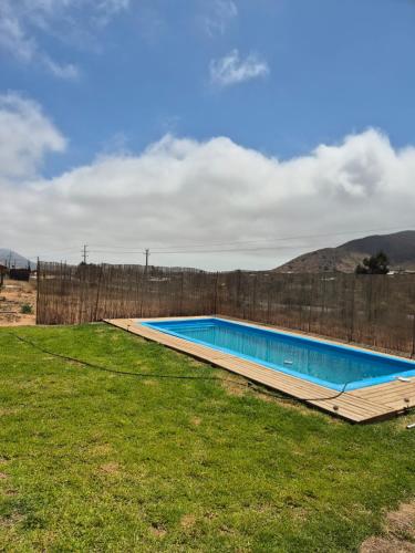 a swimming pool in a yard next to a fence at Los Olivos del Colibri in Tambillos