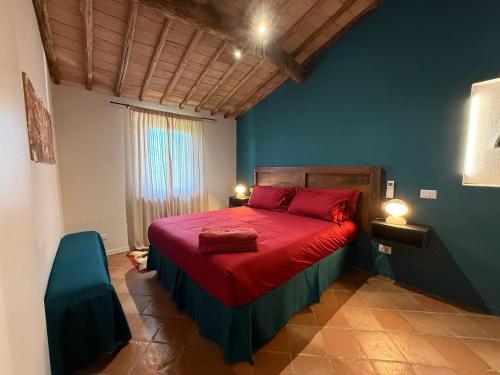 a bedroom with a red bed and a blue wall at Villa Santa Chiara in Siena