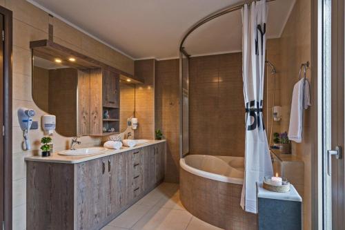 a bathroom with two sinks and a bath tub at Villa Sandy Evi by Villa Select in Astérion