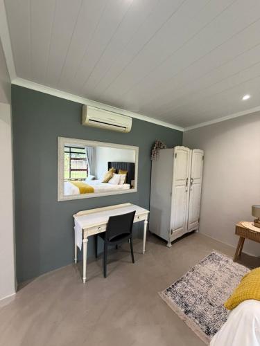 a bedroom with a desk and a bed with a window at McCrae's Garden Suite in Malmesbury