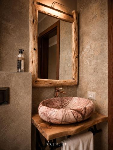 a bathroom with a sink and a mirror at Rrenjet - The Roots in Ersekë