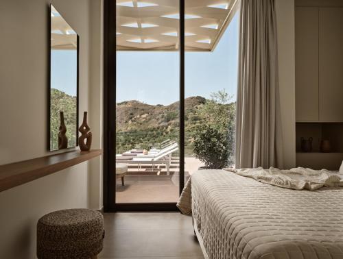 a bedroom with a bed and a view of a patio at Villa Theta by Villa Select in Kalamaki