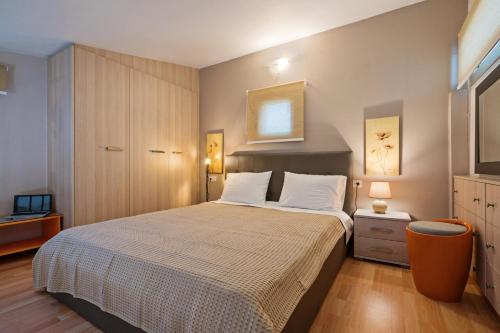 a bedroom with a large bed and a television at Villa Sandy Evi by Villa Select in Astérion