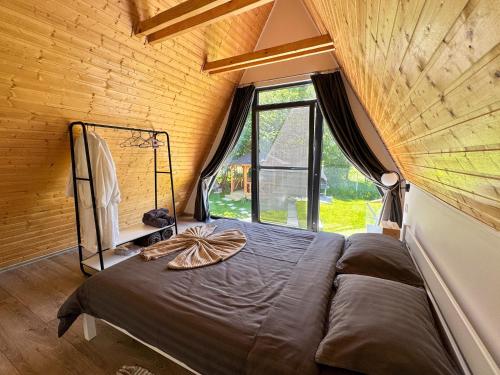 a bed in a room with a large window at Cabana Luminis in Râşnov