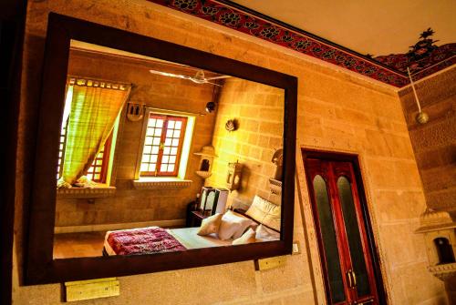 a mirror reflection of a bedroom with a bed in a room at Fort Villa in Jaisalmer