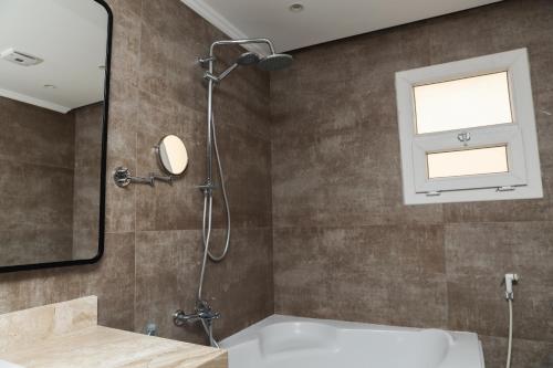 a bathroom with a shower and a tub and a mirror at Munir’s residence in Cairo