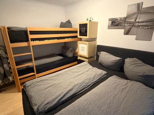 a bedroom with two bunk beds and a ladder at 2 Zimmer Apartment am Europapark - auf Wunsch klimatisiert für 10,-Aufpreis pro Nacht in Rust