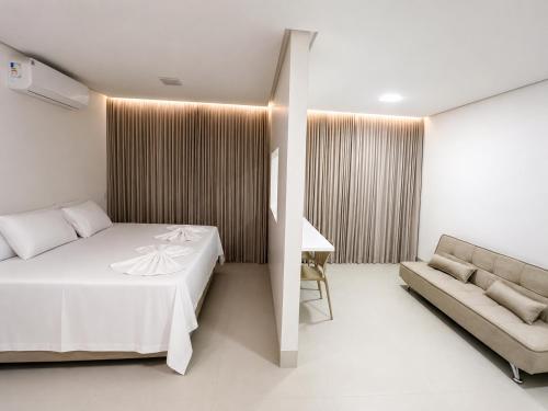 a hotel room with a bed and a couch at Lopo Palace in Porangatu