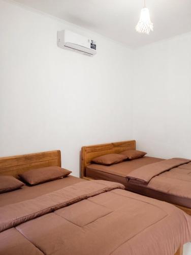 two beds sitting next to each other in a bedroom at Sarwi Endah Beach Cottage in Tepus