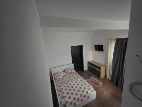 a small bedroom with a bed and a tv at Apartament Eduard in Techirghiol