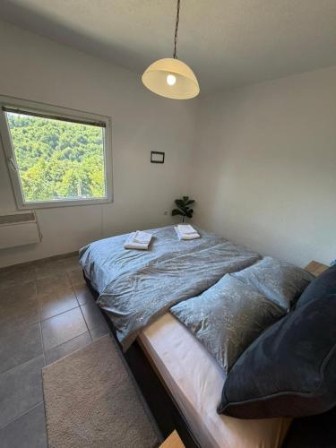 a bedroom with a large bed and a window at Vikendica BeeLux in Banja Luka