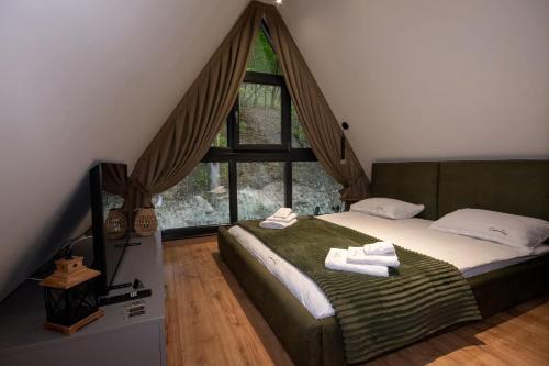 a bedroom with a bed with two towels on it at Cabana Casa Luca in Rănuşa