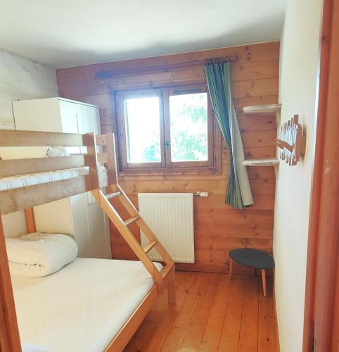 a room with two bunk beds and a window at Lapon H10 in Hauteluce