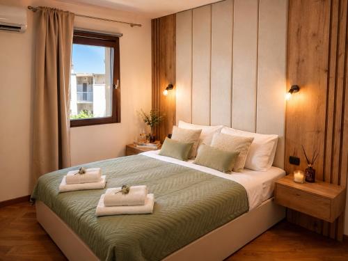 a bedroom with a large bed with towels on it at Beachfront Pearl in Rafailovici