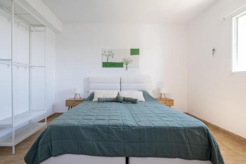 a bedroom with a bed with a green comforter at Villa 65 in Ilaniyya