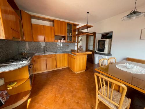 a large kitchen with wooden cabinets and a table at Casa Cadore Grea in Grea