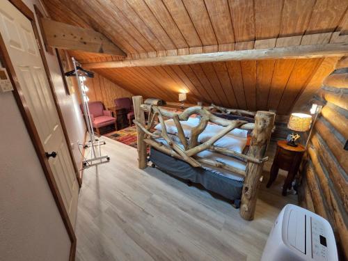 a bedroom in a log cabin with a bed at Yellowstone Motel - Adults Only - All rooms have kitchens in West Yellowstone