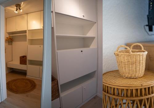 a closet with white shelves and a basket on a table at Korbzimmer Apartment in Lichtenfels