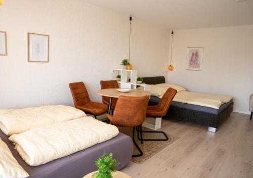 a room with two beds and a table and chairs at Korbzimmer Apartment in Lichtenfels