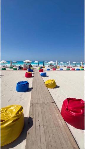 a row of colored barrels on a sandy beach at الساحل الشمالي قرية الروضة in El Alamein