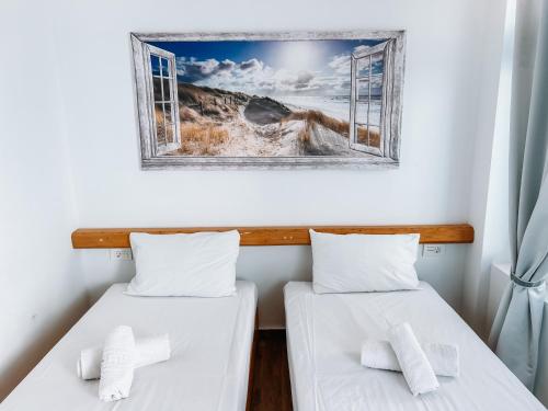 two beds in a room with a picture on the wall at il Centro in Ios Chora