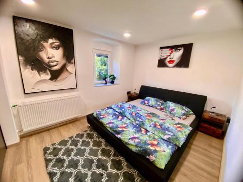 a bedroom with a bed and posters on the wall at Apartmans Lars in Rečica ob Savinji