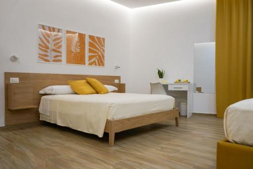 a bedroom with a bed with yellow pillows on it at La Dimora Imperiale in Rocca Imperiale