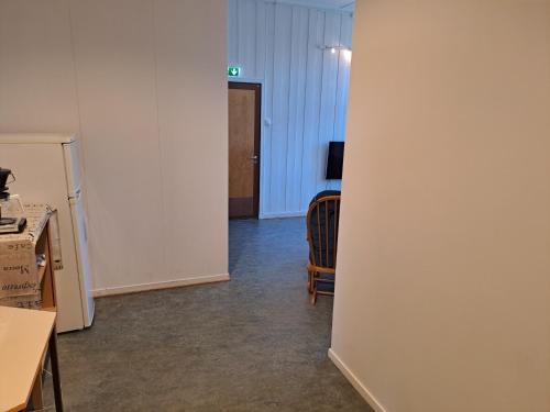 a room with a white wall and a chair at Porsangerfjorden Lodge in Børselv